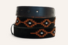 A rolled-up Texas Exes II from Zilker Belts featuring a black Argentine suede leather section with a brown geometric pattern.