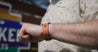 A man wearing a Zilker Belts leather Zilker Apple Watch Band in front of a sign.