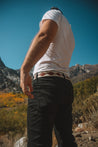 The back of a man wearing Zilker Belts jeans and a t - shirt.