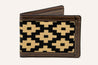 The Barton Hills Wallet by Zilker Belts, crafted from Argentine woven fabric, features a black and beige geometric pattern on its brown exterior and is displayed standing partially open.