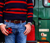 a man in jeans and a sweater standing next to a green Zilker Belts Freedom.