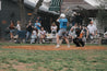 A group of people watching a baseball game while wearing Zilker Belts Moontowers.