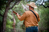 A man in a cowboy hat playing the Save Muny acoustic guitar by Zilker Belts.