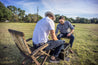 Two men sitting on Zilker Belts Horned Frog lawn chairs in a field.